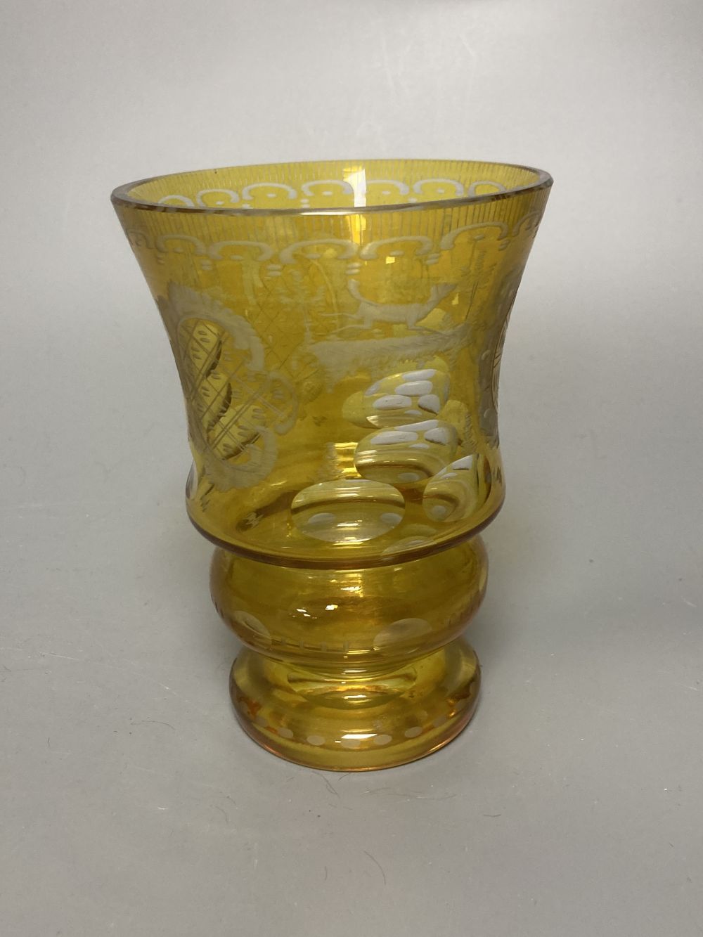 A Bohemian amber flash cut beaker vase, a pair of amber wine glass coolers, 10cm high and a floral painted opaque glass beaker vase, in